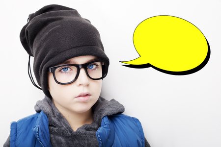 Handsome boy is wearing black cap and eyeglasses  with an empty thought bubble. Isolated on white...