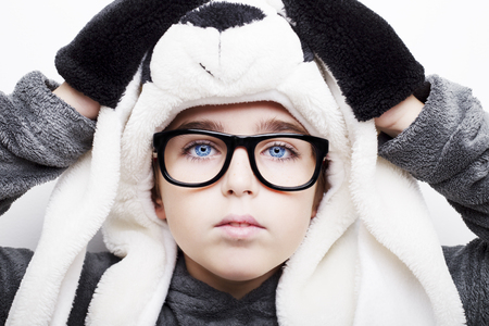 Portrait of a handsome boy in panda hat and eyeglasses on white background.の写真素材