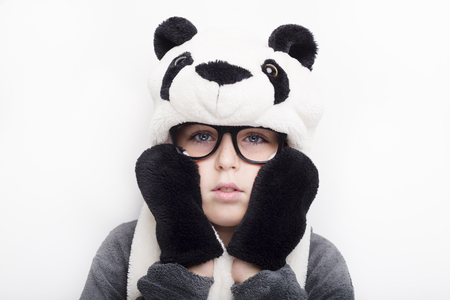 A boy in panda hat and eyeglasses on white background.の写真素材