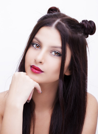 Beautiful woman with bright makeup hairstyle with horns on a white backgroundの写真素材