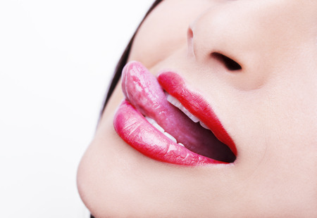 Beautiful woman leaking teeth with tongue close upの写真素材