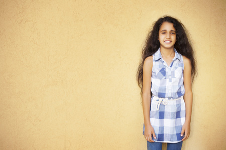 Little afro-american girl on yellow wall backgroundの写真素材