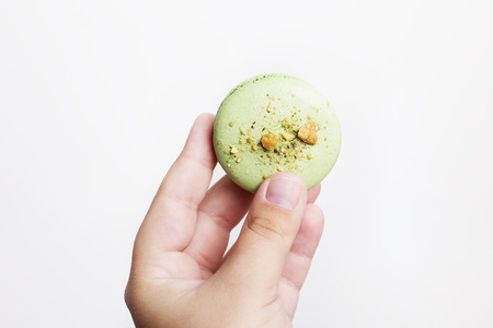 Hands holding macarons isolated on white backgroundの写真素材