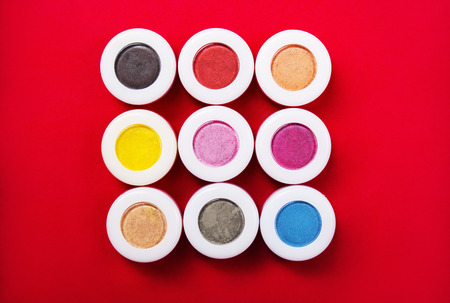 Set of colorful mineral eye shadows on red background