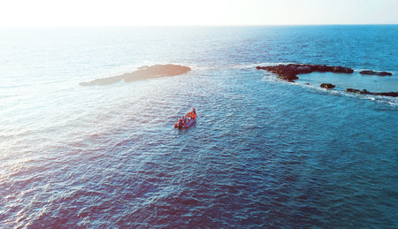 Aerial photo above rock outcrop and reef in crystal clear warm water. Coast of Mediterranean sea in Israelの写真素材