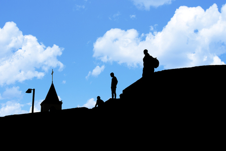 Silhouettes of people on the roof of houses. Black and white photo. Silhouettes and Contours.の写真素材