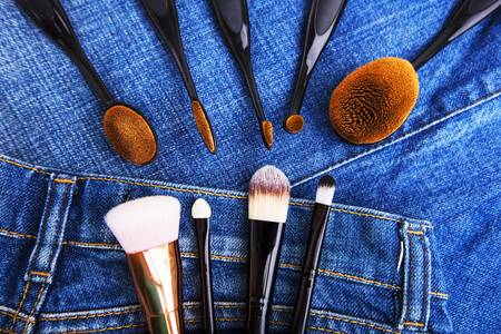 Professional makeup brushes on denim background. Women's beauty accessories.の写真素材