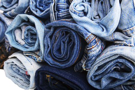 Close up rolled of blue jeans pants, dark blue denim trousers showing texture isolated on whiteの写真素材