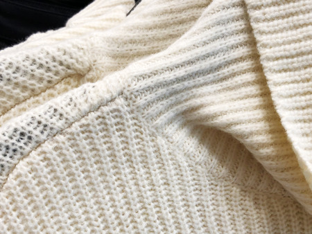 Womens sweaters on the hanger in the store. Clothes hang on a shelf in a clothes store