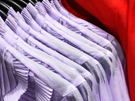 Womens shirts on the hanger in the store. Clothes hang on a shelf in a clothes storeの写真素材