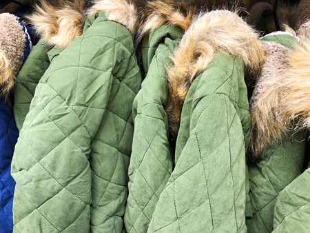 Men's and women's jackets and down jackets on the counter in the storeの写真素材