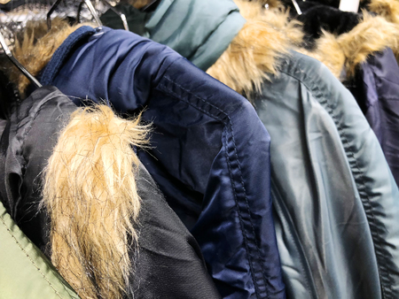 Men's and women's jackets and down jackets on the counter in the storeの写真素材