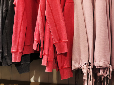 Sweaters on the hanger in the store. Clothes hang on a shelf in a clothes storeの写真素材