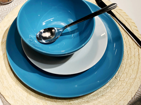 A set of cutlery: a spoon and blue plates on a wooden table. Workpiece on a wooden background. Can be used as a background menu for a restaurant. View from above. Copy space.の写真素材