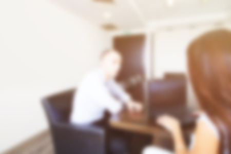 Abstract blurred people. Business people having  business conversation in office while using laptopの写真素材