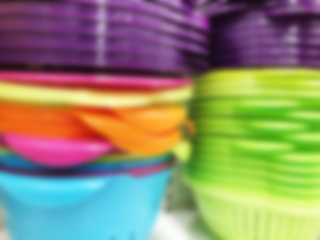 Abstract blurred background. Colorful plastic bowls displayed on shelves for sale in a supermarket.の写真素材
