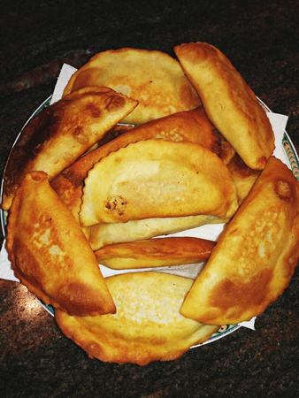 Cheburek  fried pie with meat and onions on a plate.