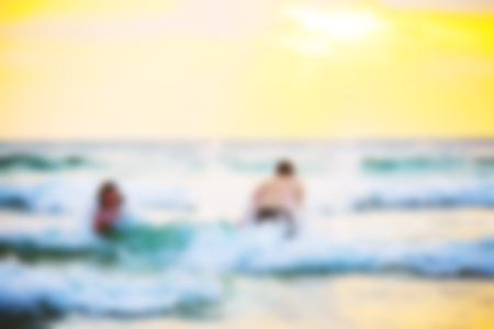 Abstract blurred background. Beautiful sunset with sea and beach. Blurred people swimming at the sea.の写真素材