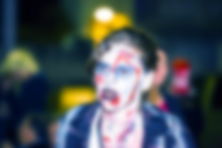 Abstract blurred background. People dressed as a zombie parades on a street during a zombie walkの写真素材