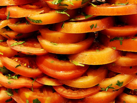 Sliced tomatoes with parsley. Sliced tomatoes. Tomatoes cut into slices for saladの写真素材