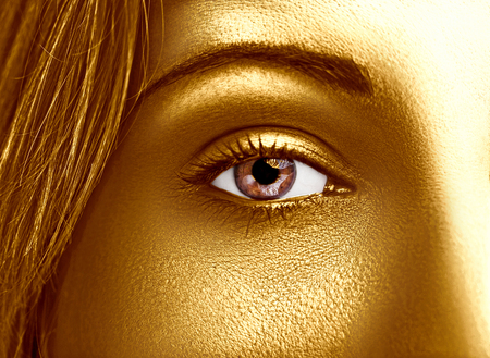 Glamour shiny gold professional makeup. Beautiful golden skin close up.の写真素材
