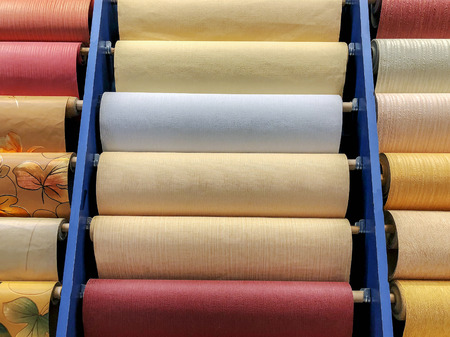 Colored wallpaper rolls on store shelves. Paper material for repair.の写真素材