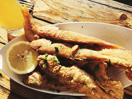 Delicious fried grilled fish on a plate in a restaurantの写真素材