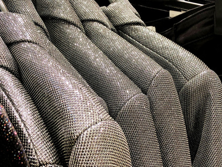 Modern clothes in a shop on a hanger. Shirts and sweaters of different colors and denim for youth. Clothes of different styles on the hanger in the showroom.の写真素材