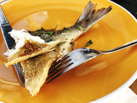 Delicious fried grilled fish on a plate in a restaurant