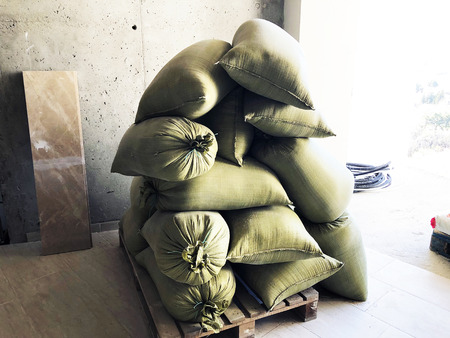 Green sandbags are lying on the ground in the construction.