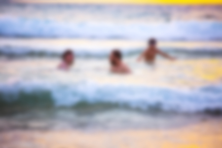 Abstract blurred background. Beautiful sunset with sea and beach. Blurred people swimming at the sea.の写真素材