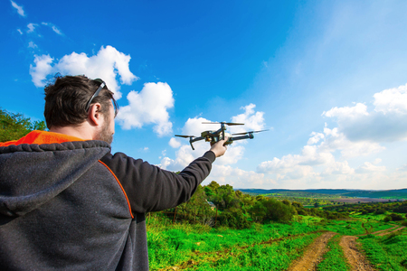 Man holds small compact drone in his hands. Pilot launches quadrupter from his palm. Drone ready to...