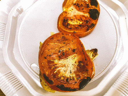 Fresh ripe red sliced tomatoes on a white plateの写真素材