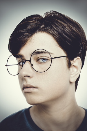 Portrait of a boy wearing eyeglasses blue eyes close, macro studio shot.の写真素材