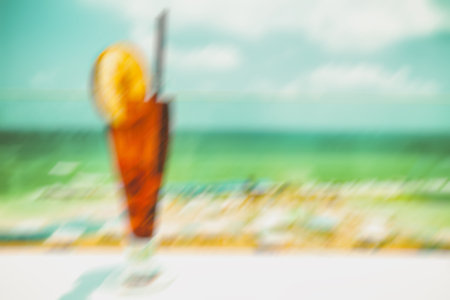 Cocktail drink on wood table on the sky background. Abstract motion blur effect backgroundの写真素材