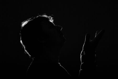 Unknown male person silhouette on black background.の写真素材