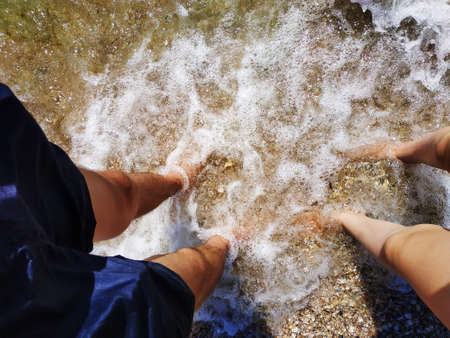 Female and male legs in the clear water at the bottom of the sea