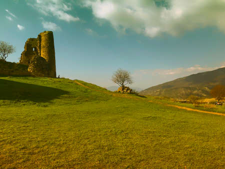 Ruins of an old fortress against the sky, panoramic view. Spring, green fields.の写真素材