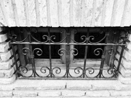 Old Tbilisi architecture, a small window in the metal bars in summer day.の写真素材