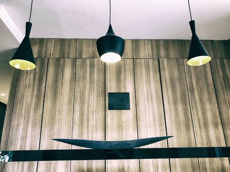 Black decorative lamps hangs from the ceiling. A modern chandelier at homeの写真素材
