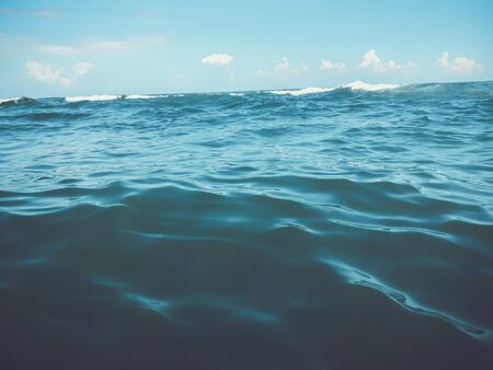 Close up of sea wave. Front view on beautiful sea wave on sandy beach. Summer sunny day, blue sky,...