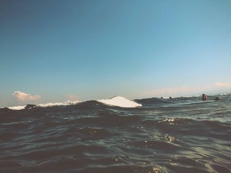 Close up of sea wave with splashes. Front view on beautiful sea wave on sandy beach. Summer sunny...