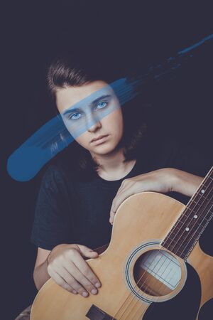 Portrait of a teenager playing guitar in studio