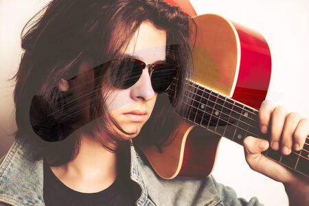 Portrait of a teenager playing guitar in studio