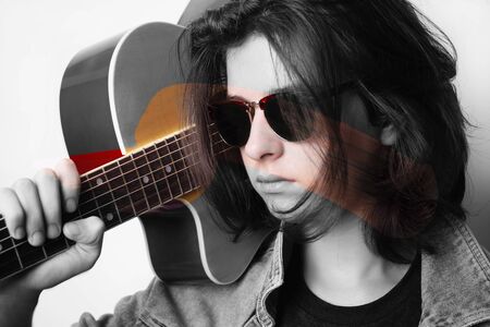 Portrait of a teenager playing guitar in studio