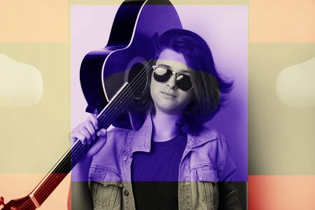 Portrait of a teenager with guitar in studio