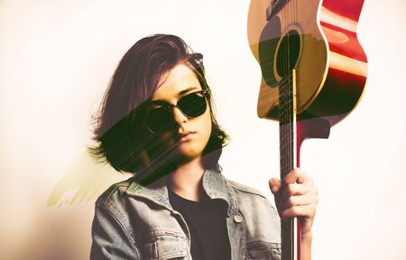 Portrait of a teenager with guitar in studio