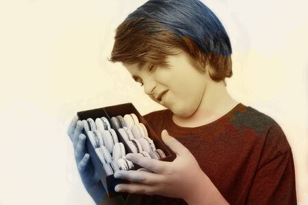 Handsome boy holds in his hands macaroni over white background