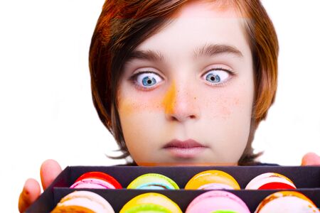 Handsome boy holds in his hands macaroni over white backgroundの写真素材