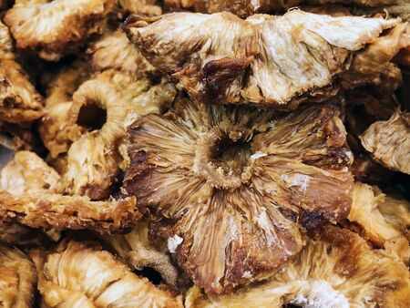 Heap of dry yellow pineapple slices for sale at market.の写真素材